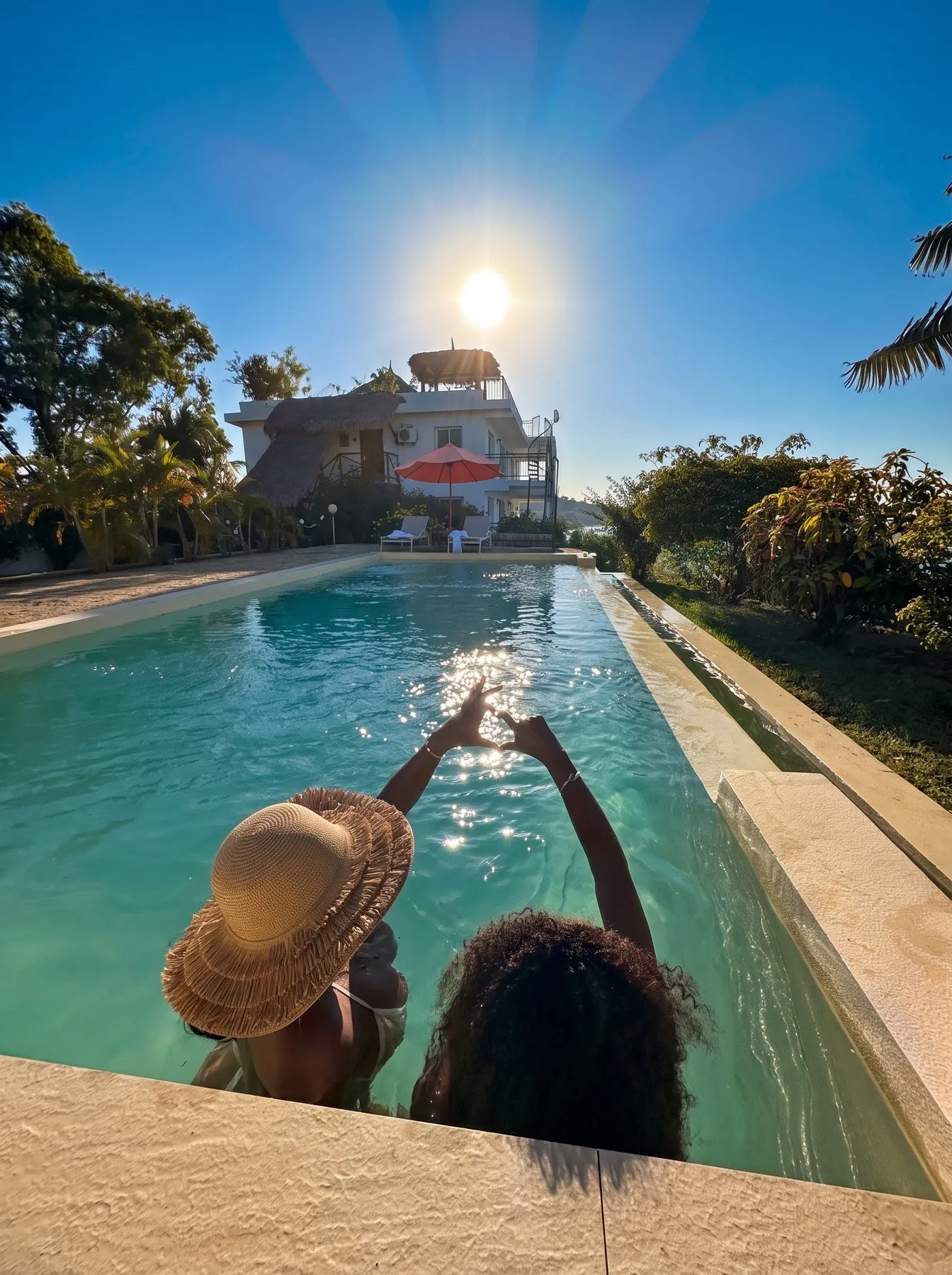 La piscine partagée — un cœur avec les mains, face à la résidence